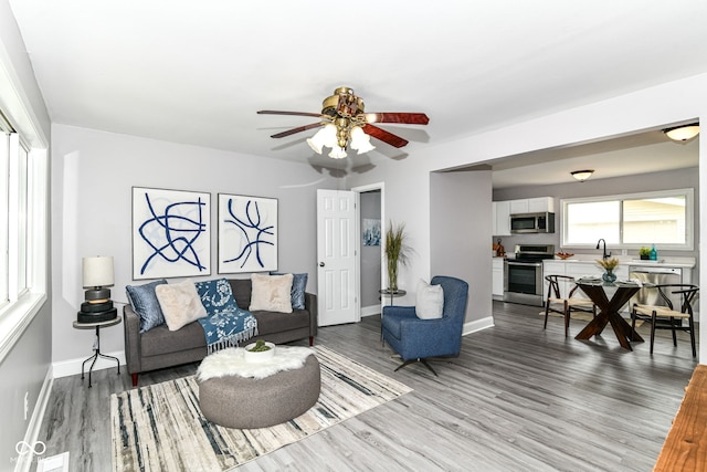 1820 Hemlock Ln, Plainfield, IN 46168 - living area featuring light wood-style floors, a ceiling fan, and baseboards