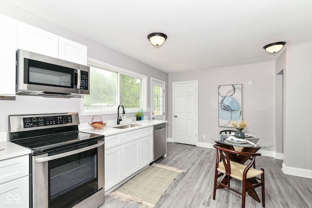 1820 Hemlock Ln, Plainfield, IN 46168 - kitchen featuring appliances with stainless steel finishes, a sink, light countertops, and white cabinets