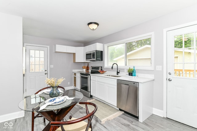 1820 Hemlock Ln, Plainfield, IN 46168 - kitchen with stainless steel appliances, a sink, baseboards, and light countertops