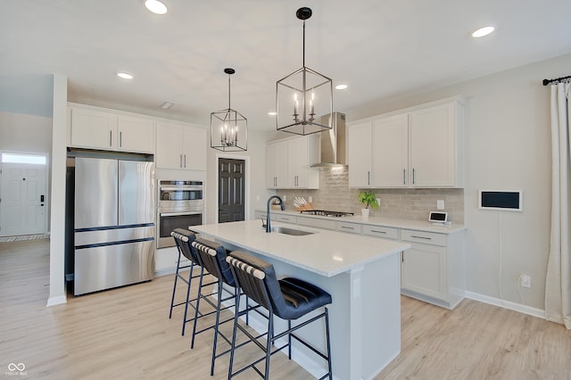 4163 Ironclad Dr, Bargersville, IN 46106 - kitchen with appliances with stainless steel finishes, wall chimney exhaust hood, light wood finished floors, white cabinetry, and recessed lighting
