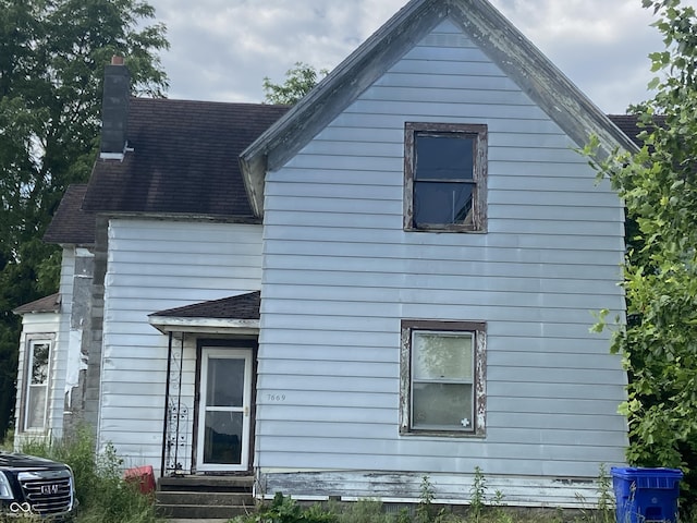 7669 W 100 N, Tipton, IN 46072 - view of property exterior featuring central AC unit, a chimney, and roof with shingles
