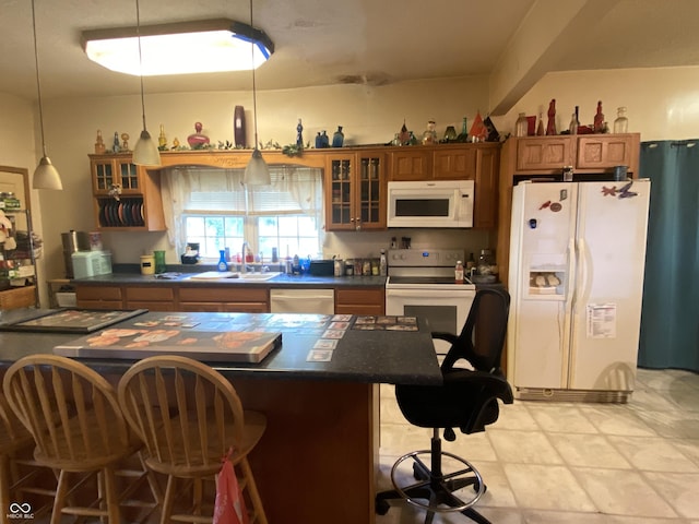 7669 W 100 N, Tipton, IN 46072 - kitchen with white appliances, a sink, dark countertops, brown cabinetry, and a breakfast bar area