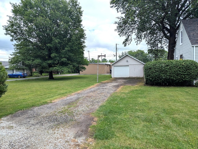 1637 Meridian St, Columbus, IN 47201 - view of grassy yard with asphalt driveway, a garage, and an outdoor structure