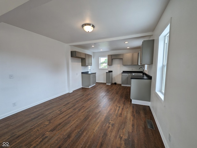 102 S W St, Milroy, IN 46156 - kitchen with dark countertops, dark wood finished floors, a sink, baseboards, and gray cabinets