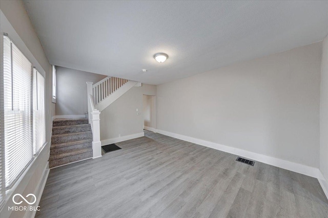 418 Eastern Ave, Indianapolis, IN 46201 - unfurnished living room featuring stairway and wood finished floors