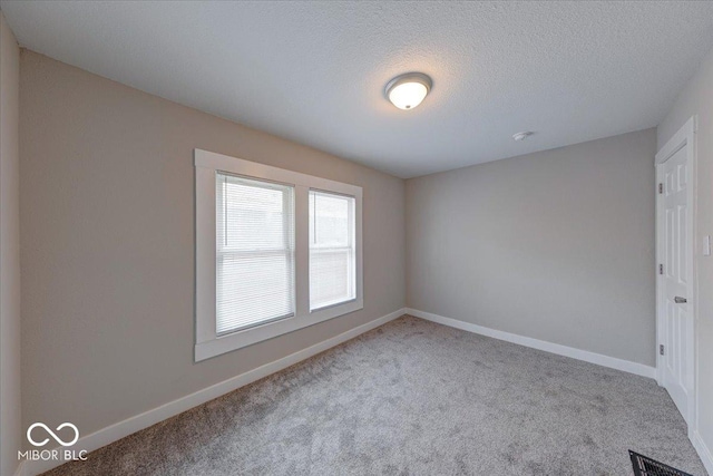 418 Eastern Ave, Indianapolis, IN 46201 - unfurnished bedroom with carpet floors and a textured ceiling