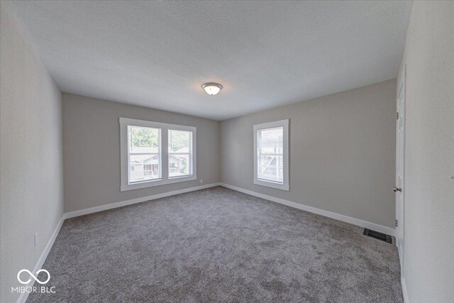 418 Eastern Ave, Indianapolis, IN 46201 - carpeted spare room featuring a textured ceiling and baseboards