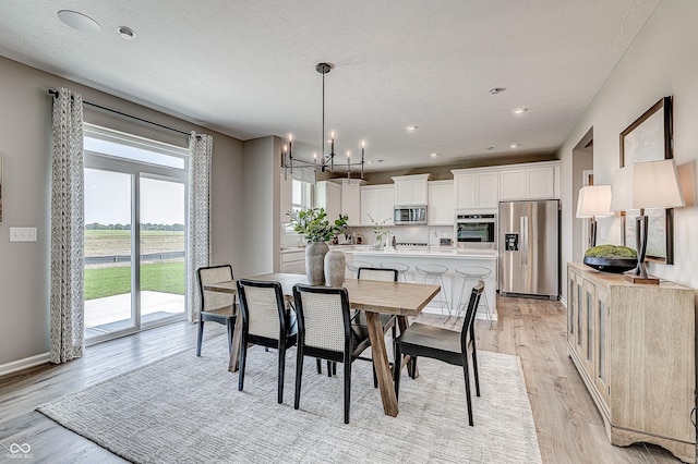 587 Bluestem Ln, New Whiteland, IN 46184 - dining area featuring a chandelier, light wood-style flooring, recessed lighting, and baseboards