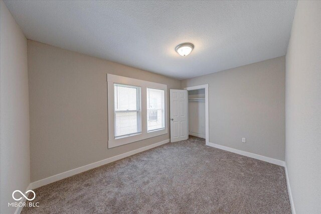 420 Eastern Ave, Indianapolis, IN 46201 - unfurnished bedroom featuring carpet, a closet, and a textured ceiling
