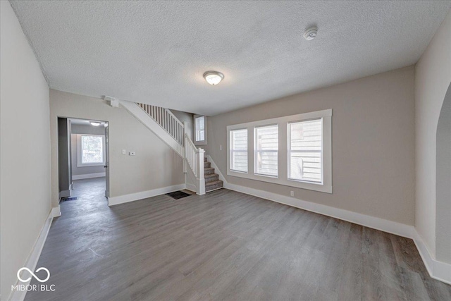 420 Eastern Ave, Indianapolis, IN 46201 - unfurnished living room featuring stairway, wood finished floors, and a textured ceiling