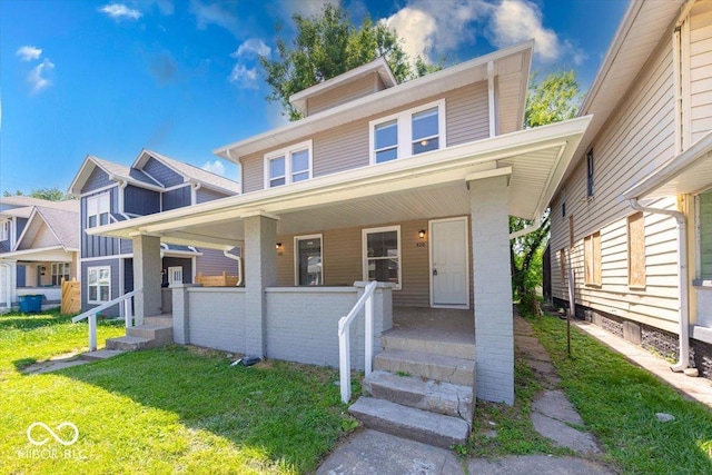 420 Eastern Ave, Indianapolis, IN 46201 - view of front facade with a porch, a front lawn, and brick siding