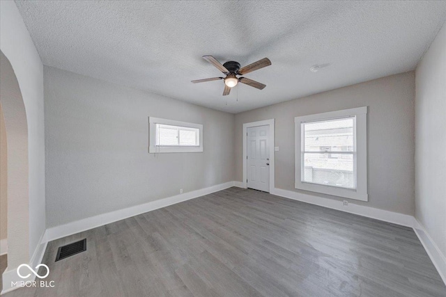 420 Eastern Ave, Indianapolis, IN 46201 - spare room with wood finished floors, a ceiling fan, arched walkways, and a textured ceiling
