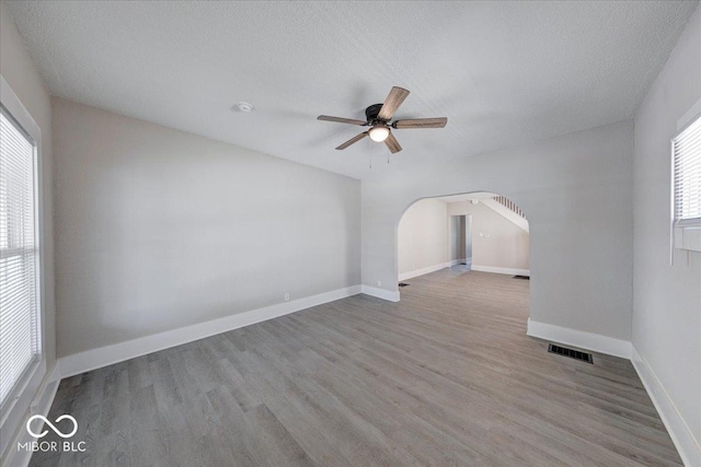 420 Eastern Ave, Indianapolis, IN 46201 - unfurnished room with wood finished floors, a ceiling fan, arched walkways, and a textured ceiling