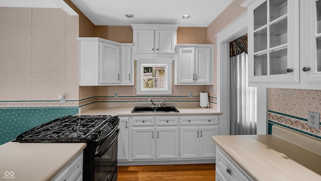 753 Walnut St, Franklin, IN 46131 - kitchen with gas stove, white cabinetry, light countertops, light wood finished floors, and glass insert cabinets