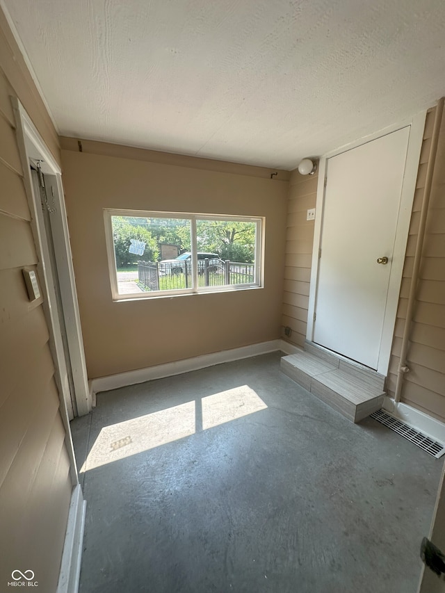 2180 N Irwin St, Indianapolis, IN 46219 - empty room with unfinished concrete floors and baseboards