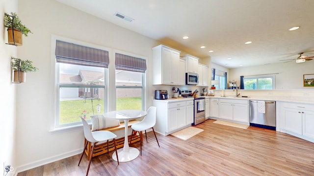 217 Saint Andrews Ave, Edinburgh, IN 46124 - kitchen featuring appliances with stainless steel finishes, a sink, recessed lighting, light wood finished floors, and white cabinetry