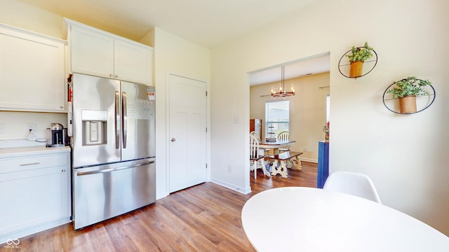 217 Saint Andrews Ave, Edinburgh, IN 46124 - kitchen with stainless steel fridge with ice dispenser, light wood-style floors, a chandelier, white cabinets, and light countertops