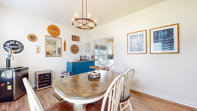 217 Saint Andrews Ave, Edinburgh, IN 46124 - dining space featuring wine cooler, a chandelier, light wood-style floors, and baseboards