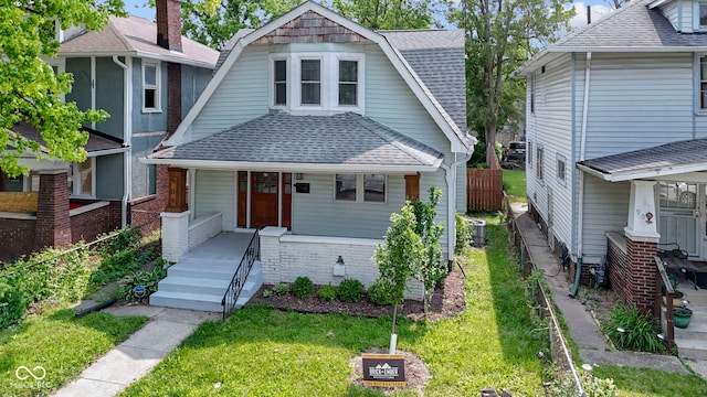 909 N Parker Ave, Indianapolis, IN 46201 - view of front facade with covered porch, a shingled roof, central AC, and a gambrel roof