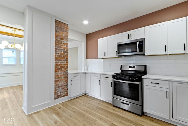 909 N Parker Ave, Indianapolis, IN 46201 - kitchen featuring appliances with stainless steel finishes, light countertops, light wood-type flooring, decorative backsplash, and recessed lighting