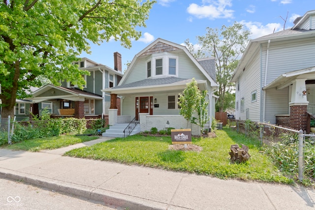 909 N Parker Ave, Indianapolis, IN 46201 - colonial inspired home featuring a gambrel roof, a porch, a shingled roof, and brick siding