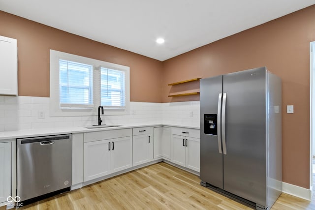 909 N Parker Ave, Indianapolis, IN 46201 - kitchen with appliances with stainless steel finishes, a sink, open shelves, light wood-style flooring, and backsplash