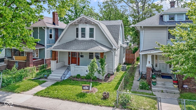 909 N Parker Ave, Indianapolis, IN 46201 - view of front of house with covered porch, a shingled roof, a gate, and a gambrel roof