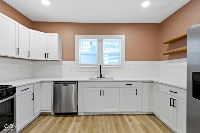 909 N Parker Ave, Indianapolis, IN 46201 - kitchen featuring stainless steel appliances, a sink, open shelves, light wood-type flooring, and light countertops