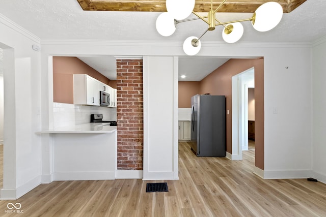 909 N Parker Ave, Indianapolis, IN 46201 - kitchen with stainless steel appliances, light wood-style floors, light countertops, baseboards, and a textured ceiling