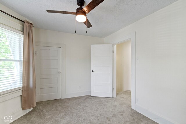 909 N Parker Ave, Indianapolis, IN 46201 - unfurnished bedroom with carpet flooring, a textured ceiling, a ceiling fan, and baseboards