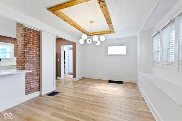 909 N Parker Ave, Indianapolis, IN 46201 - unfurnished dining area with a tray ceiling, a textured ceiling, healthy amount of natural light, baseboards, and light wood-style flooring