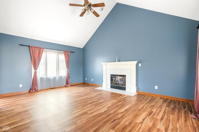 7082 Hunters Ridge Dr, Plainfield, IN 46168 - unfurnished living room featuring ceiling fan, a tiled fireplace, high vaulted ceiling, and wood finished floors