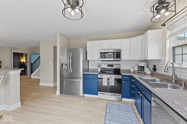 2580 Bluewood Way, Plainfield, IN 46168 - kitchen featuring appliances with stainless steel finishes, blue cabinetry, white cabinetry, and tasteful backsplash