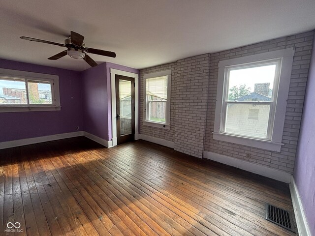 18 E Church St, Brazil, IN 47834 - spare room featuring baseboards, hardwood / wood-style flooring, brick wall, and ceiling fan