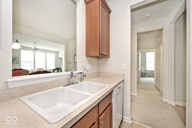 15937 Marsala Dr, Fishers, IN 46037 - kitchen featuring a sink, white dishwasher, brown cabinets, light countertops, and light colored carpet