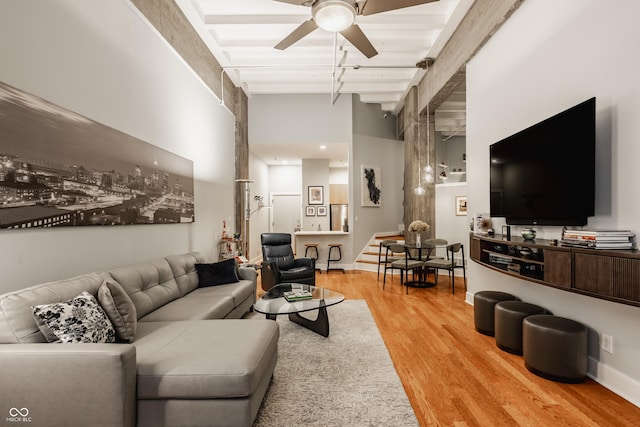 611 N Park Ave Unit 104, Indianapolis, IN 46204 - living room with light wood finished floors, beamed ceiling, a ceiling fan, stairway, and a towering ceiling