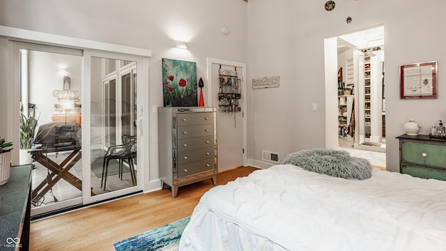611 N Park Ave Unit 104, Indianapolis, IN 46204 - bedroom featuring wood finished floors, access to outside, a walk in closet, and a high ceiling