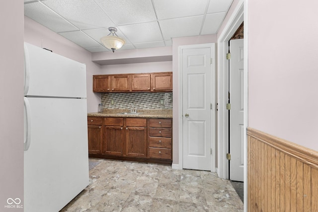 1350 Inverness Farms Rd, Martinsville, IN 46151 - kitchen featuring freestanding refrigerator, a drop ceiling, tasteful backsplash, wainscoting, and brown cabinetry