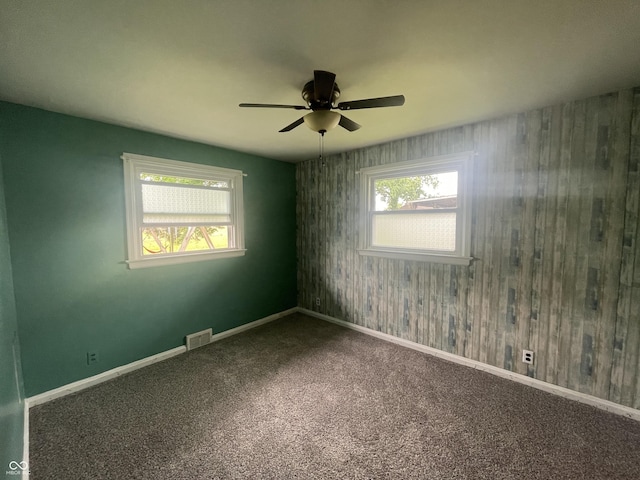 4363 Roosevelt Dr, Columbus, IN 47201 - carpeted spare room with healthy amount of natural light, a ceiling fan, wooden walls, and baseboards