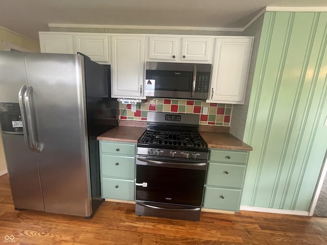 4363 Roosevelt Dr, Columbus, IN 47201 - kitchen with stainless steel appliances, white cabinets, wood finished floors, decorative backsplash, and dark countertops
