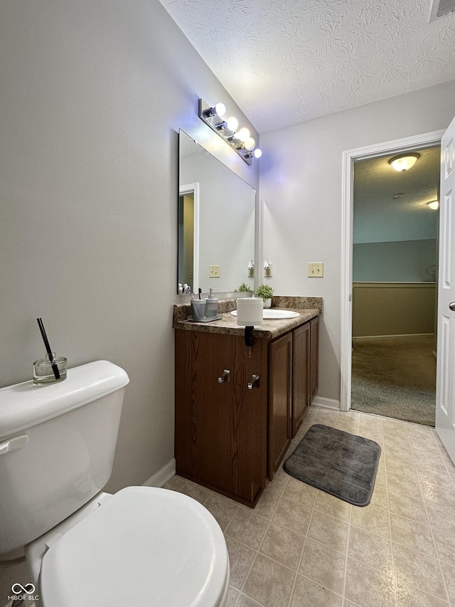 4925 Chip Shot Ln, Indianapolis, IN 46235 - full bathroom with toilet, tile patterned flooring, double vanity, a textured ceiling, and baseboards