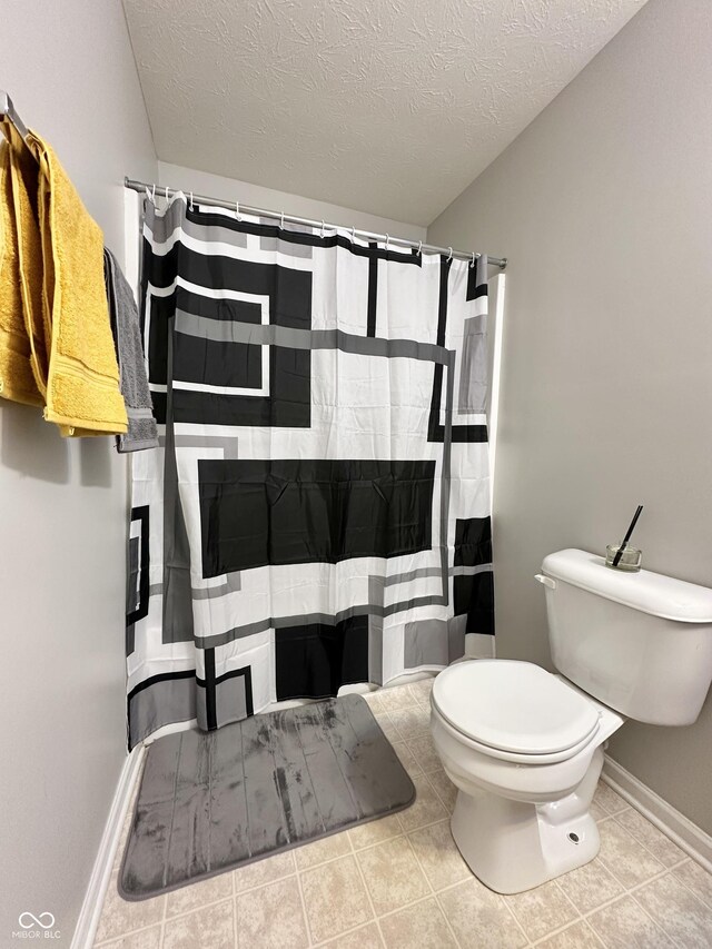 4925 Chip Shot Ln, Indianapolis, IN 46235 - bathroom with toilet, a textured ceiling, baseboards, tile patterned floors, and a shower with curtain