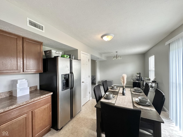 4925 Chip Shot Ln, Indianapolis, IN 46235 - dining area with a chandelier, a textured ceiling, and light floors