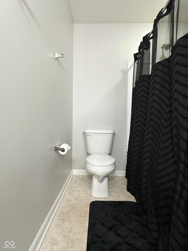 4925 Chip Shot Ln, Indianapolis, IN 46235 - bathroom with tile patterned floors, toilet, baseboards, and a shower with shower curtain