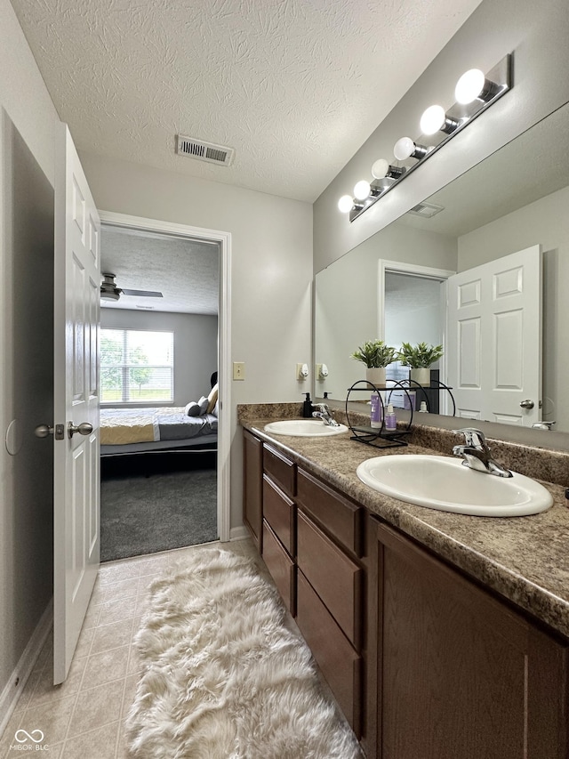 4925 Chip Shot Ln, Indianapolis, IN 46235 - ensuite bathroom featuring double vanity, tile patterned flooring, a textured ceiling, and baseboards