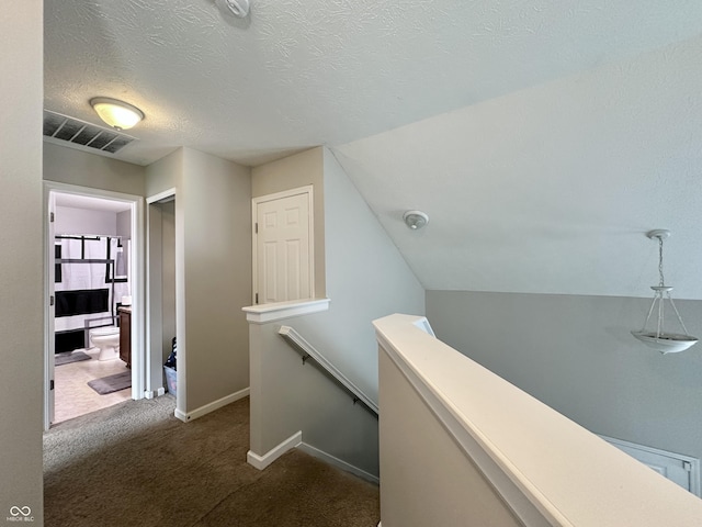 4925 Chip Shot Ln, Indianapolis, IN 46235 - hall with an upstairs landing, dark colored carpet, baseboards, and a textured ceiling