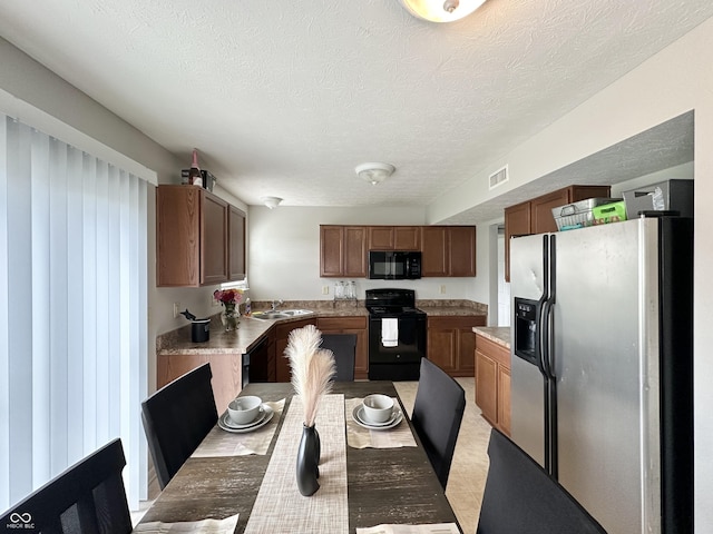 4925 Chip Shot Ln, Indianapolis, IN 46235 - kitchen with black appliances, a textured ceiling, light countertops, and brown cabinetry