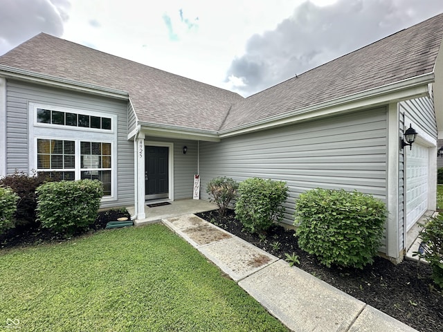 4925 Chip Shot Ln, Indianapolis, IN 46235 - entrance to property featuring roof with shingles, a yard, and a garage