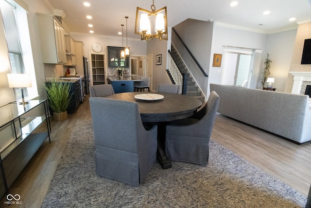 139 Wayfinder Dr, West Lafayette, IN 47906 - dining room with a chandelier, wood finished floors, a fireplace, recessed lighting, and stairway
