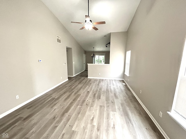 10922 Snowdrop Way, Indianapolis, IN 46235 - unfurnished living room with a ceiling fan, wood finished floors, lofted ceiling, baseboards, and a chandelier